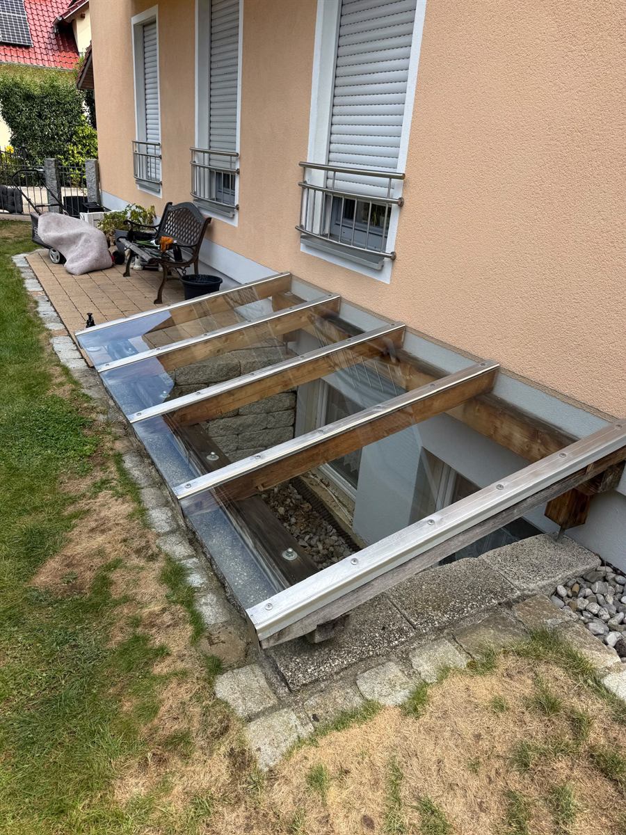 Glasdach über dem Kellerabgang nach der Reinigung, klares Glas und saubere Rahmen
