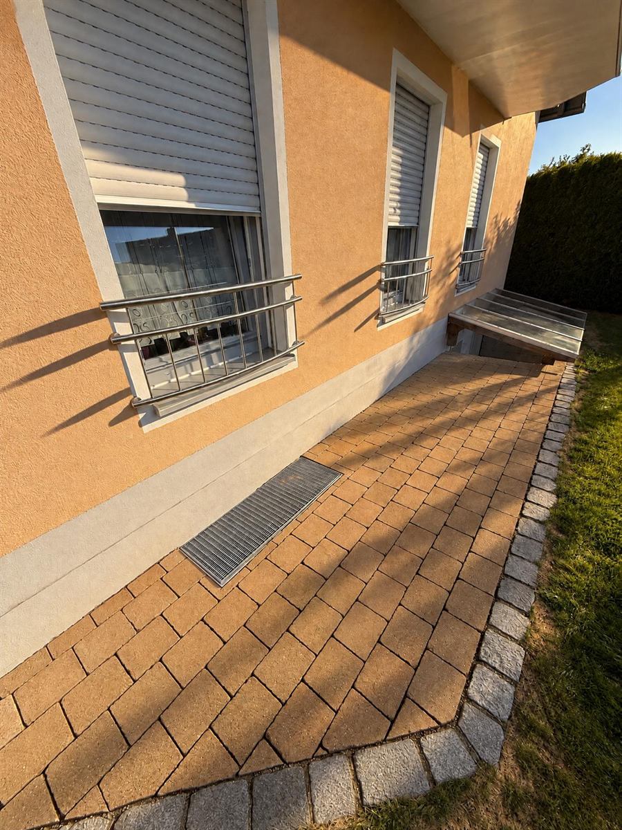 Pflasterweg an der Hauswand nach der Steinreinigung, gleichmäßig sauber